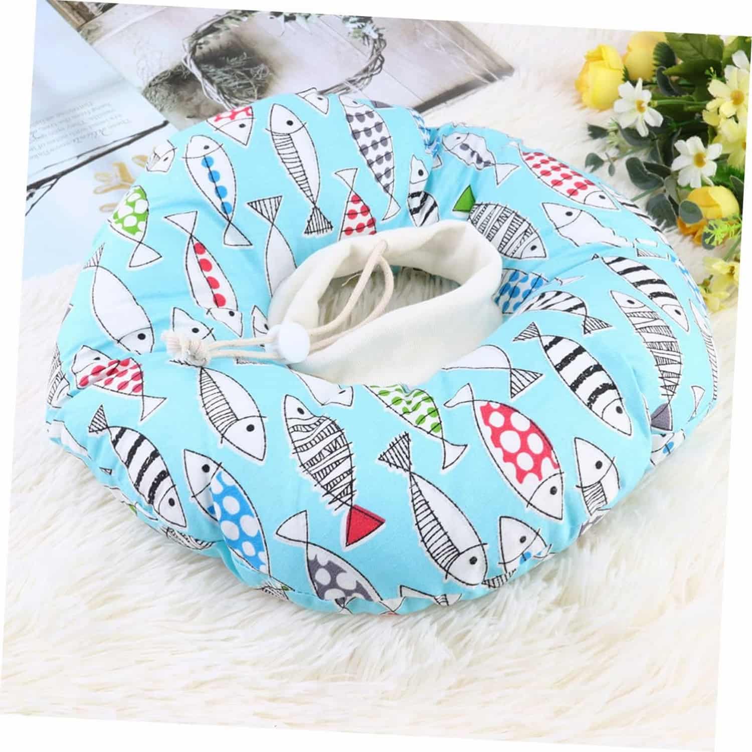 Soft inflatable donut cat recovery collar with printed pattern, worn by silver tabby cat resting on floor