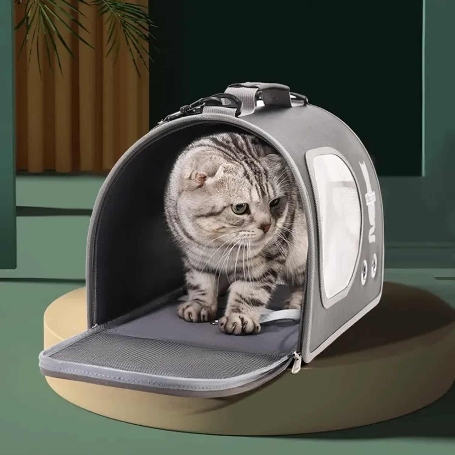 Structured Oxford cloth pet shoulder carrier with circular mesh window and luggage sleeve, shown mounted on suitcase