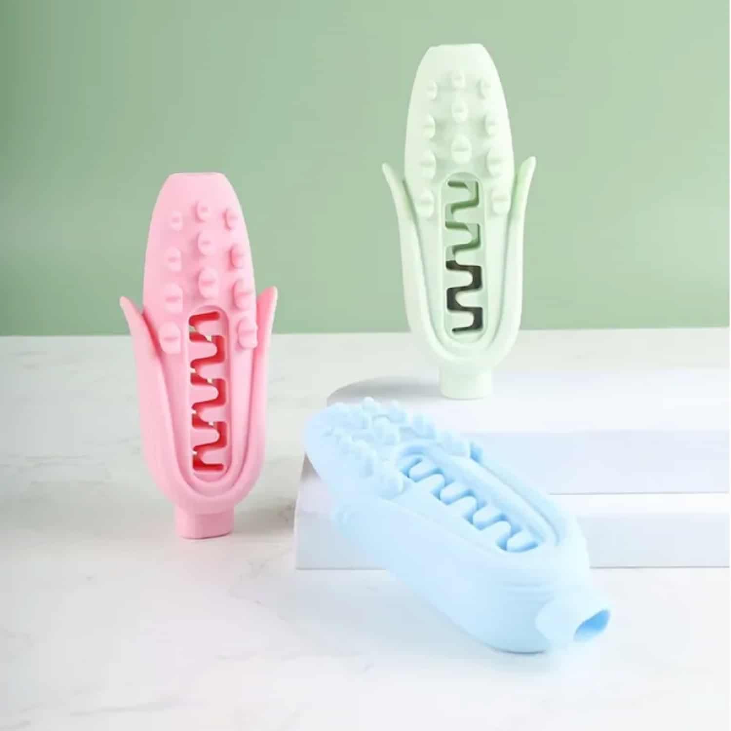 Corn-shaped food-grade silicone dog chew toy in pink, blue, and green